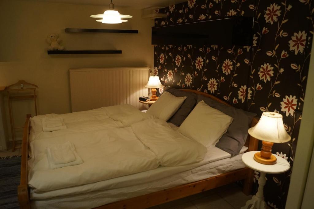 a bedroom with a bed with a lamp and a table at Eriks Bädd och Pentry in Hillerstorp