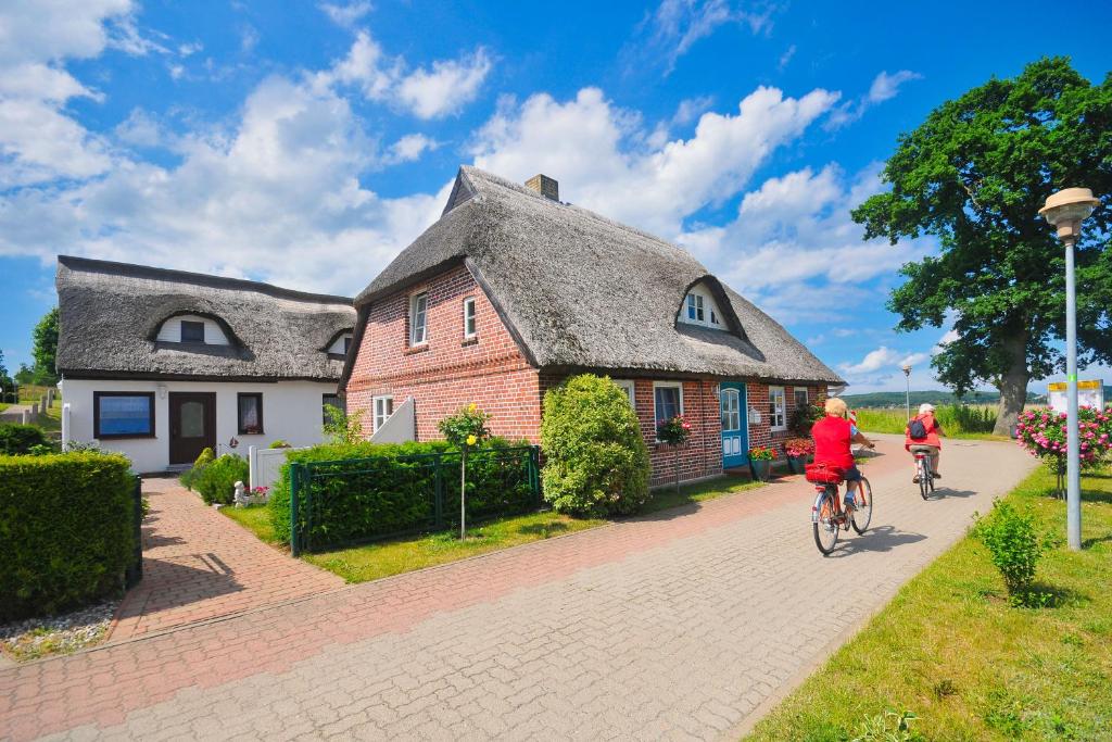 2 personnes à vélo devant une maison dans l'établissement Ferienwohnung Adermann Moritzdorf, à Sellin