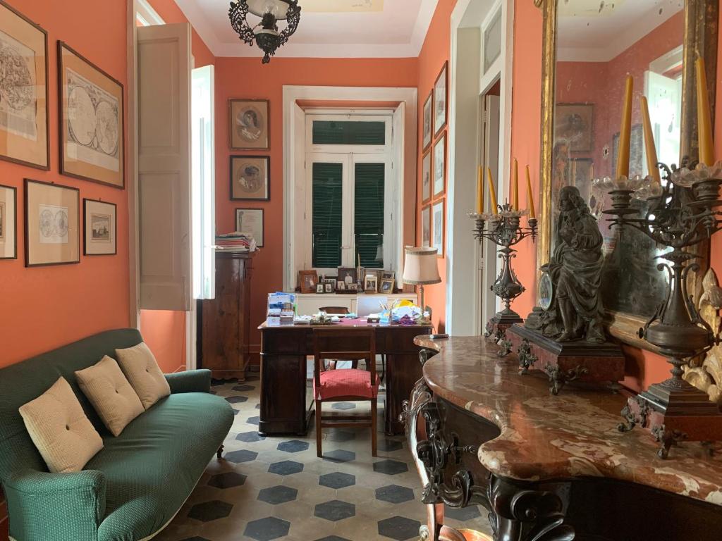 a living room with a green couch and a desk at Villino Eleonora in Parghelia