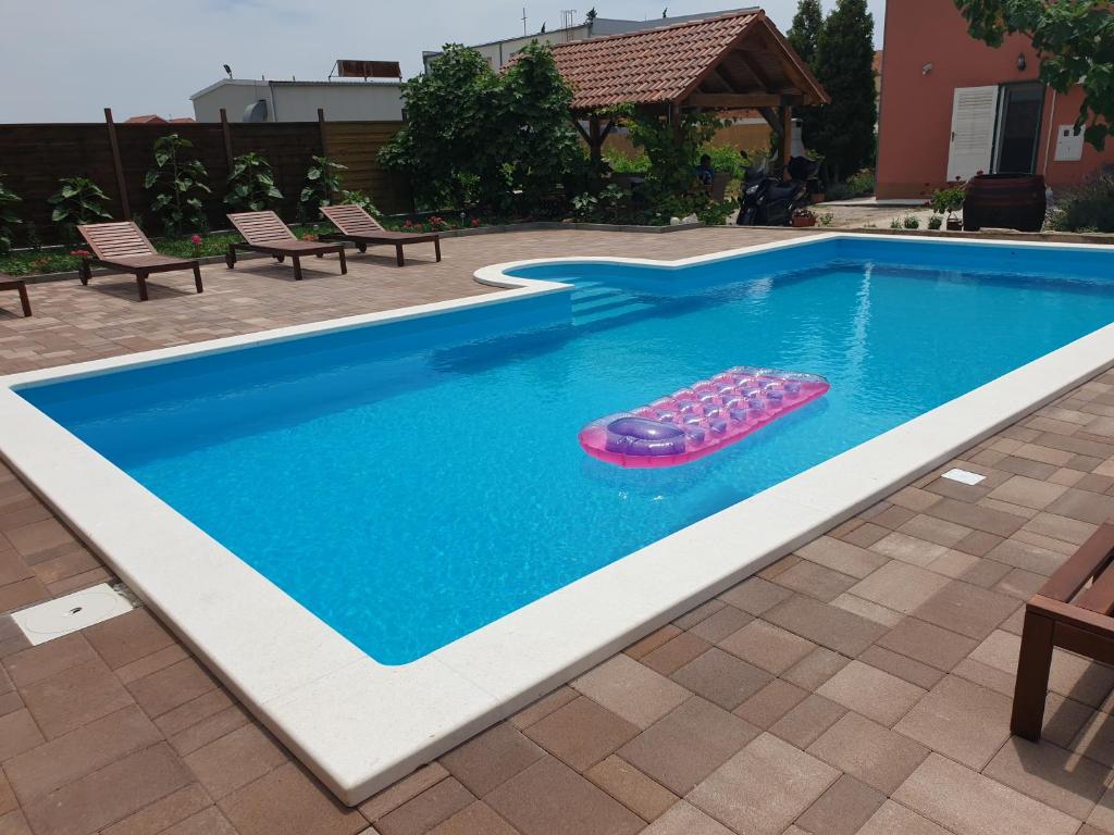 uma piscina com um flutuador na água em Apartment Smilje em Šibenik