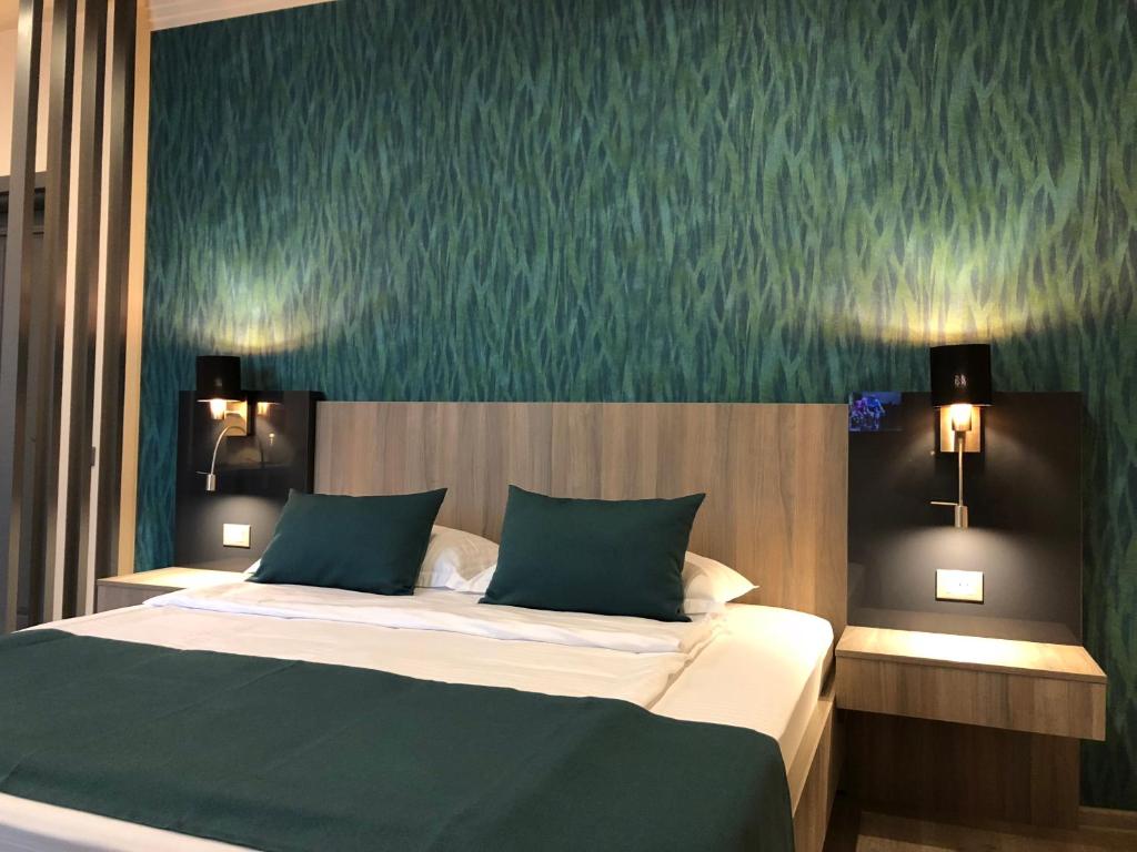 ピアトラ・ネアムツにあるPensiunea Lidoの緑の壁のベッドルーム1室