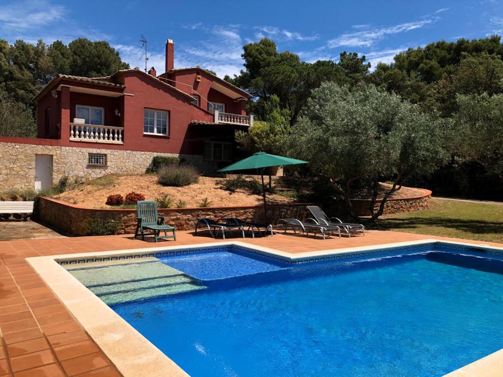 a swimming pool in front of a house at Casa Pepe in Regencós