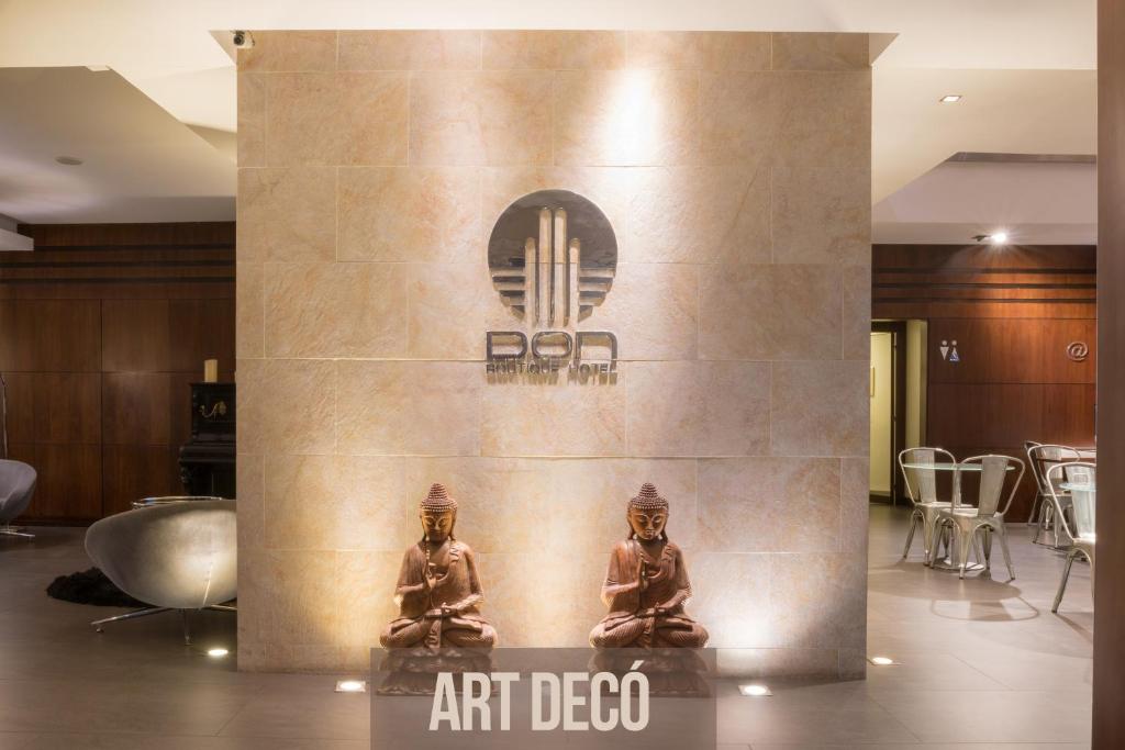 a lobby with a statue of two people sitting in a room at Don Boutique Hotel Montevideo in Montevideo