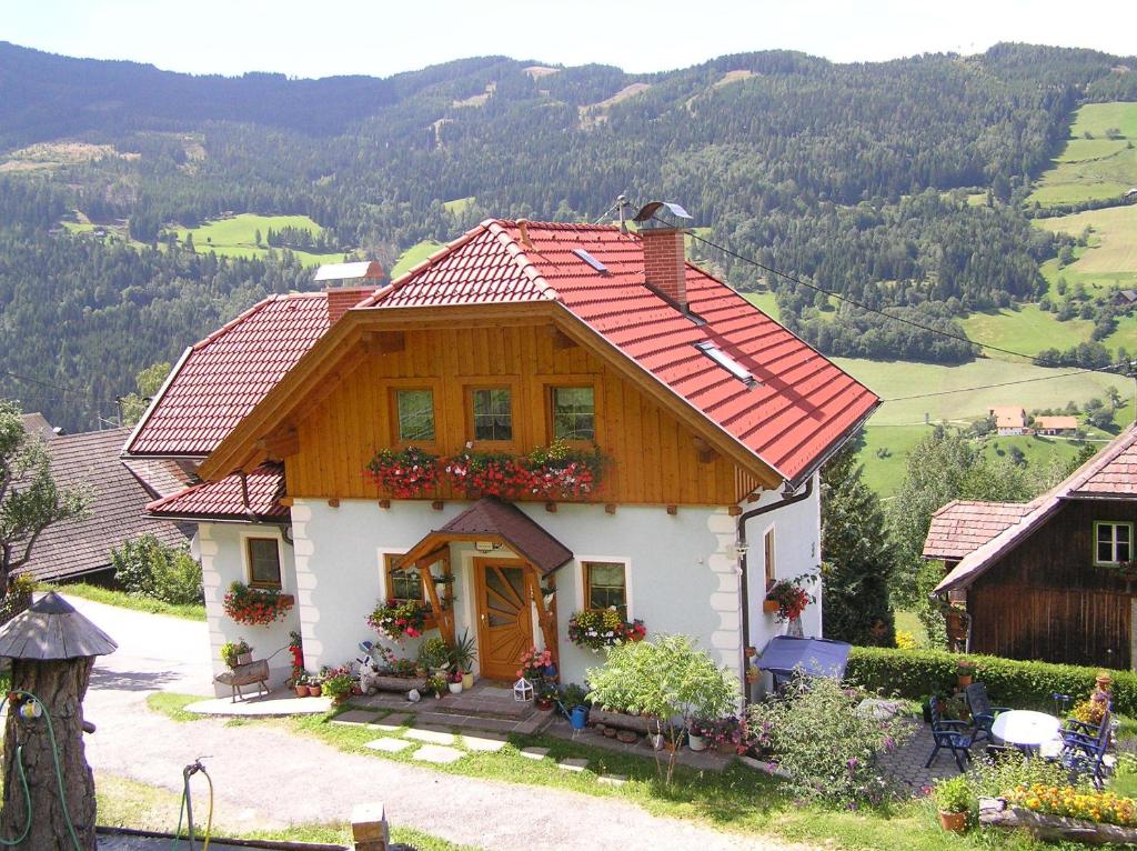 a house with a red roof on a mountain at Ferienhaus Pirker in Eisentratten