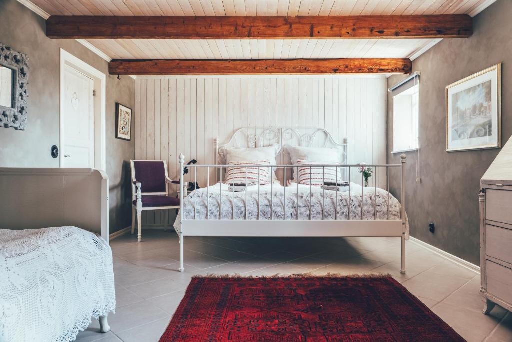 a bedroom with a white bed and a red rug at Farmors Lada in Glommen