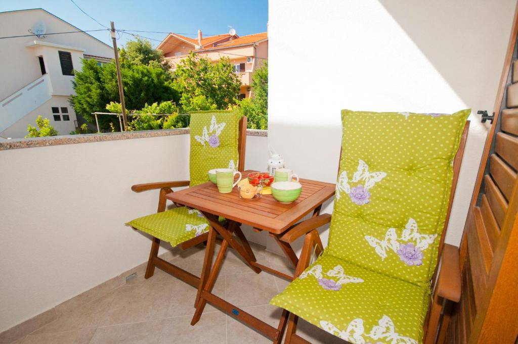 a small balcony with a wooden table and chairs at Apartment Zvone in Baška