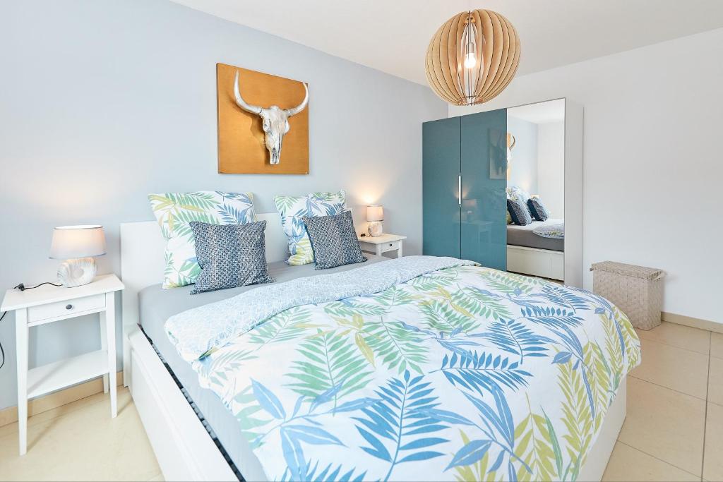 Schlafzimmer mit einem Bett mit einer blauen und weißen Bettdecke in der Unterkunft Ferienwohnung Bella Vista in Bernkastel-Kues