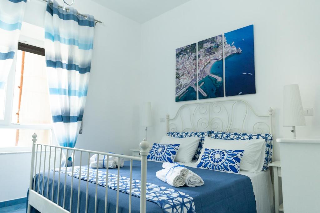 Un dormitorio azul y blanco con una cama con almohadas azules y blancas en Velia34 en Salerno