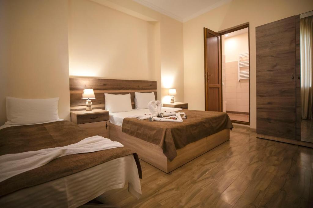 une chambre d'hôtel avec 2 lits et 2 lampes dans l'établissement Guest House MK, à Gori