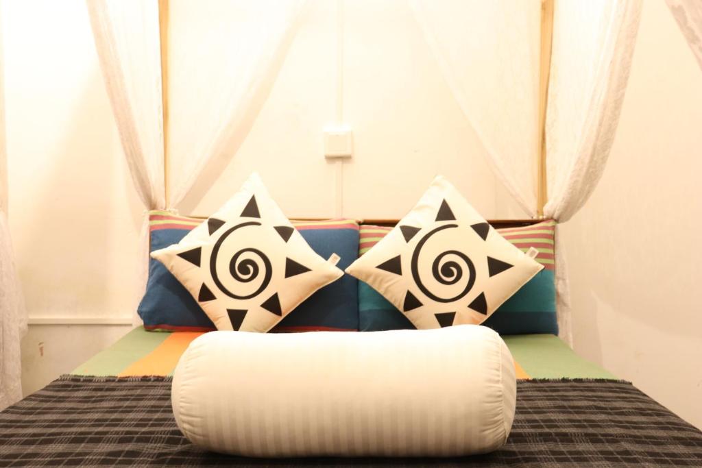 a bed with four pillows on it with a bean bag at Zion White House in Nuwara Eliya