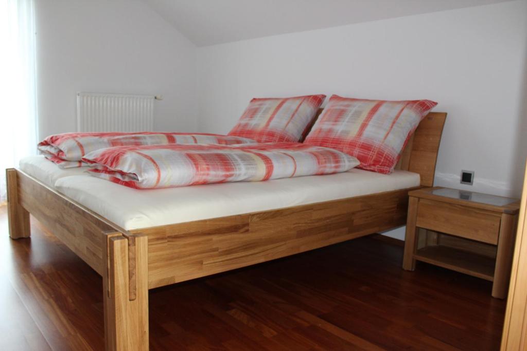 a bed with red and white pillows on top of it at Ferienwohnung Lückl in Mettersdorf am Saßbach