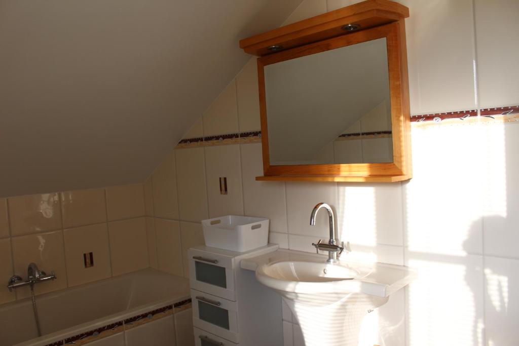 a bathroom with a sink and a mirror and a tub at Ferienwohnung Lückl in Mettersdorf am Saßbach
