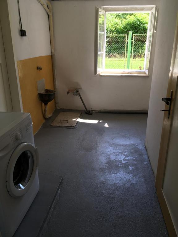 an empty room with a washing machine and a window at Ubytování U Trůdy in Smržovka