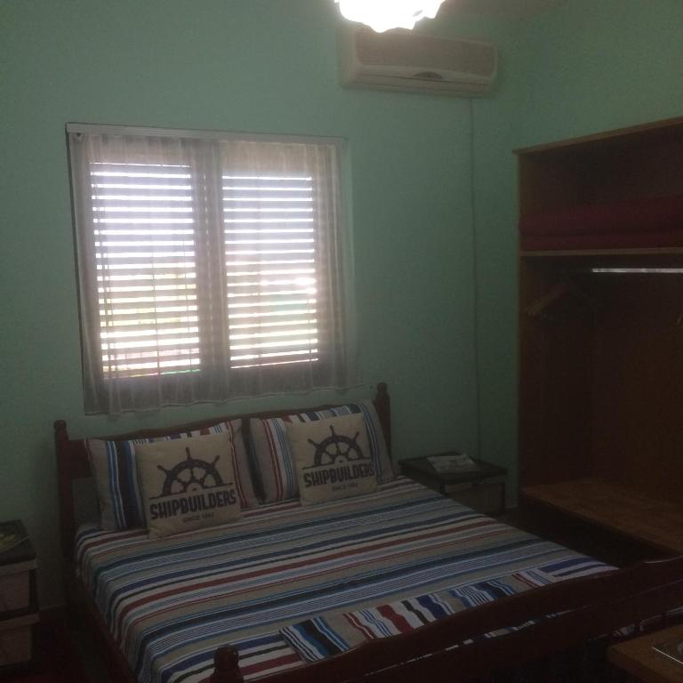 a small bedroom with a bed with a window at H and H Guesthouse in Velipojë