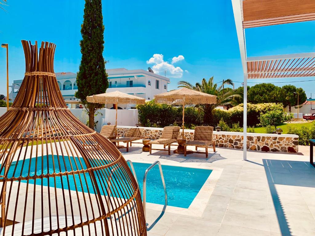 a bird cage sitting next to a swimming pool at Mythos Luxury Villa in Faliraki