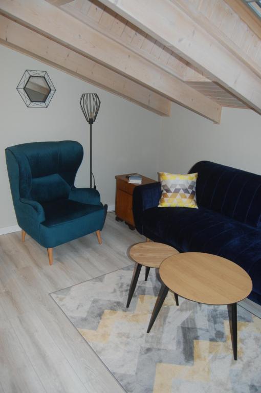 a living room with a blue couch and a table at Apartament Rybacka12 in Rewa