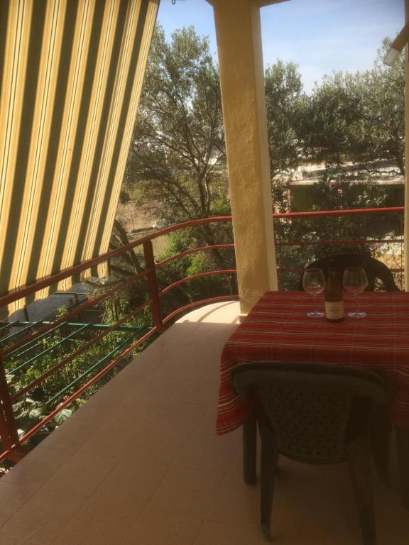 a table on the balcony of a house with a view at H and H Guesthouse in Velipojë