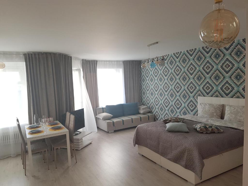 1 dormitorio con cama, mesa y sofá en Vanilla Sky Apartments, en Sillamäe