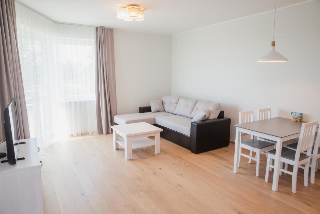 ein Wohnzimmer mit einem Sofa und einem Tisch in der Unterkunft Tiiru beachside apartment in Pärnu