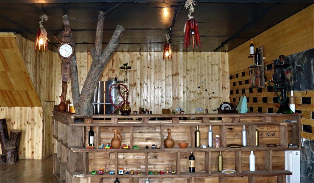 a room with a large wooden shelf with wine bottles at HOMEWOOD in Stepantsminda