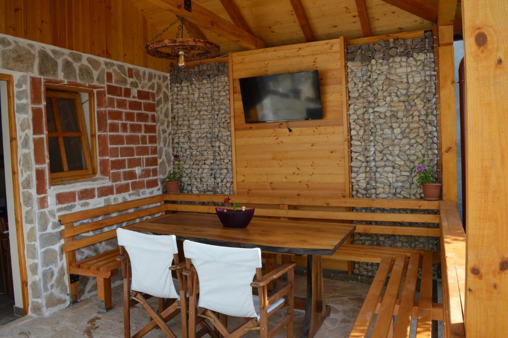 a wooden table and chairs on a porch with a television at Villa Marija in Ohrid