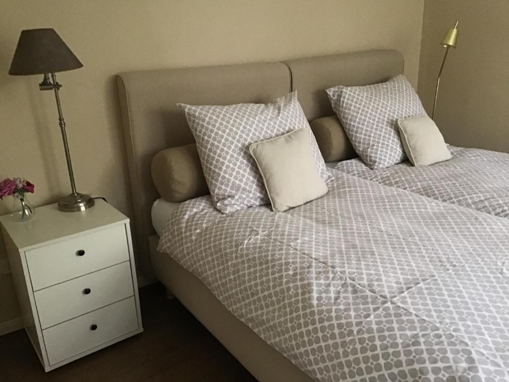 een slaapkamer met een bed met 2 kussens en een nachtkastje bij TimeOut-Breda in Breda