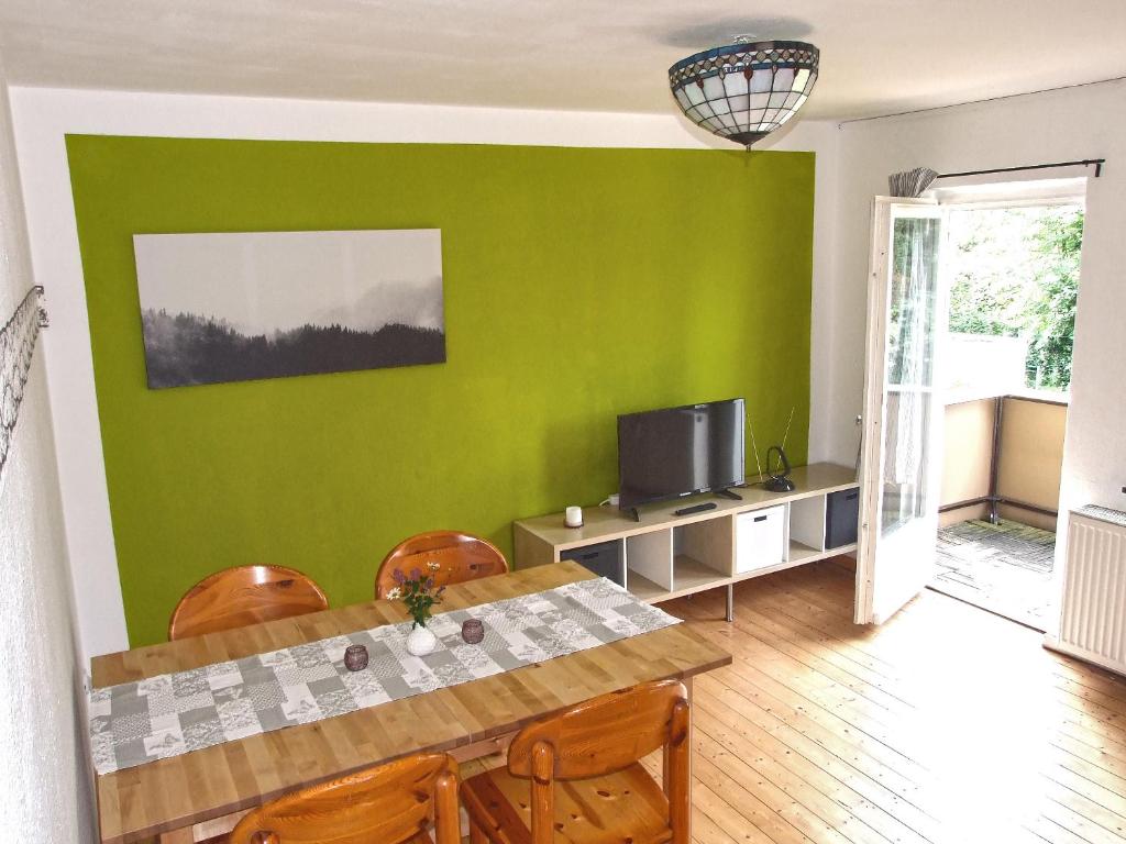 a dining room with a green wall at Ferienwohnung Goslar - Georgenberg / Entspannen im Harz / Mittendrin in Goslar