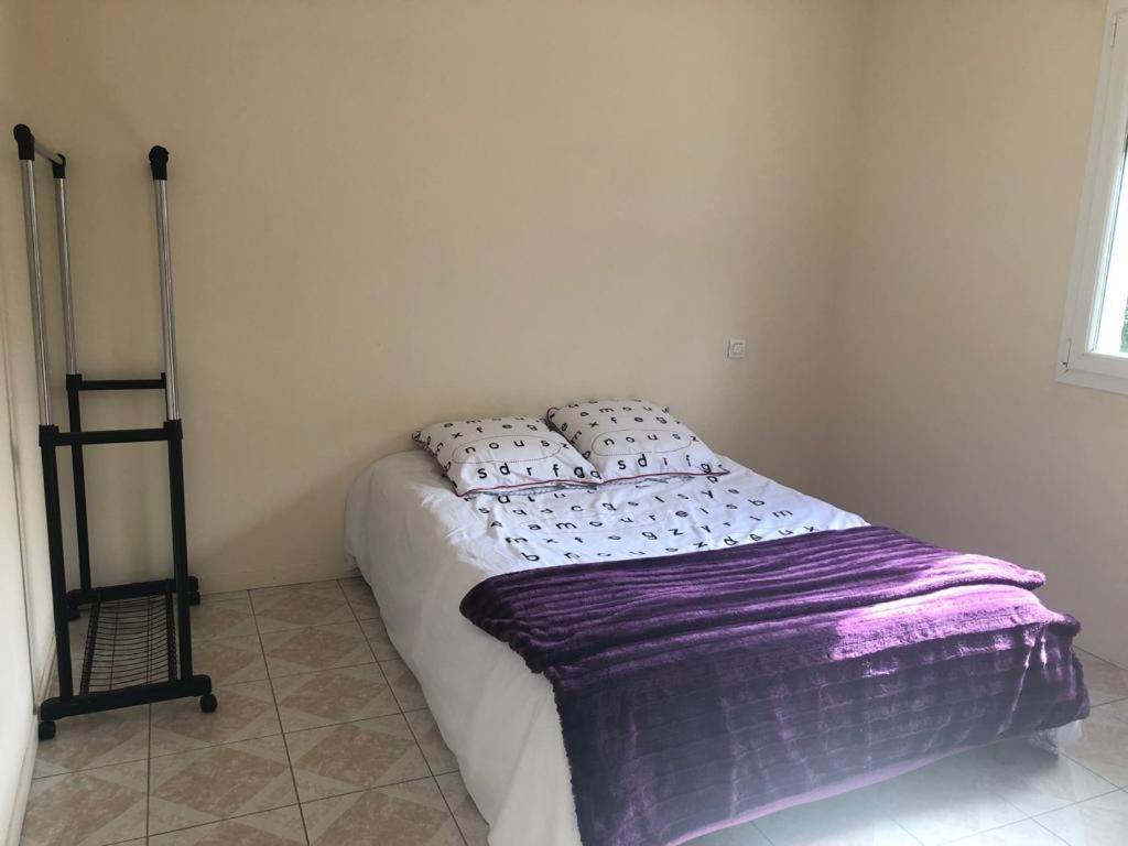 um quarto com uma cama com um cobertor roxo em Villa plein pied rez-de-chaussée+1 avec dépendance em Cenon