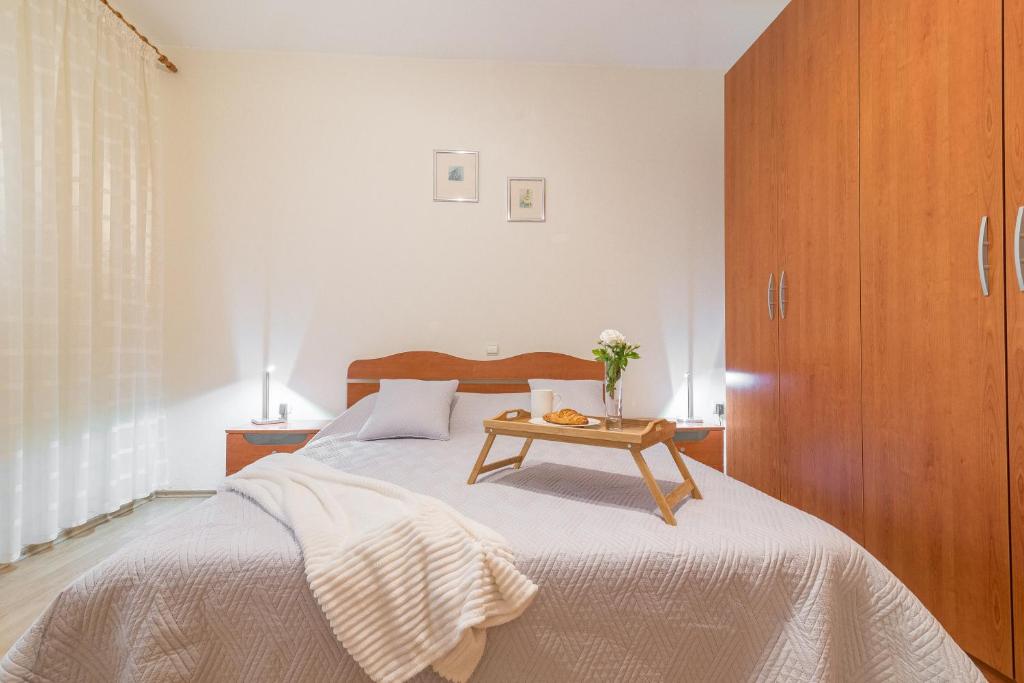 a bedroom with a bed and a wooden cabinet at Apartment Kate's Family Place in Zadar