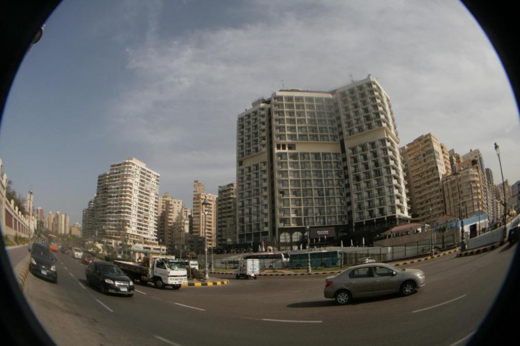 a busy city street with cars and buildings at شقق ابراج شيراتون المنتزه in Alexandria