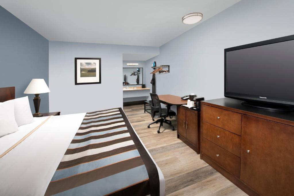 a hotel room with a bed and a flat screen tv at Ivy City Hotel in Washington
