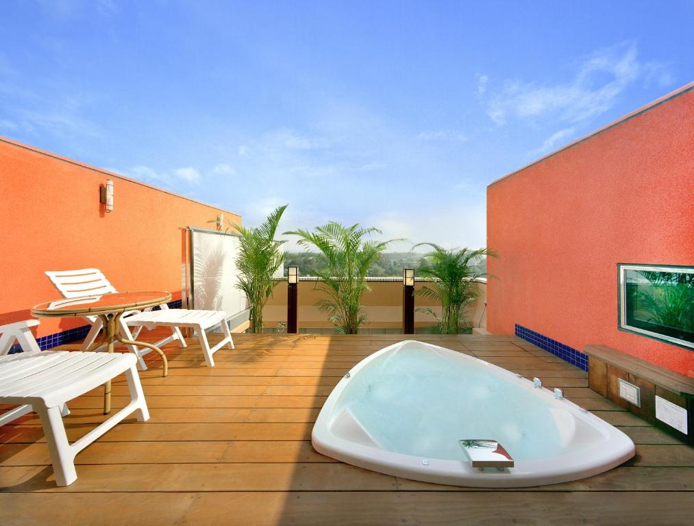 a bath tub on a deck with a table and chairs at ホテル イコイ in Kawaguchi