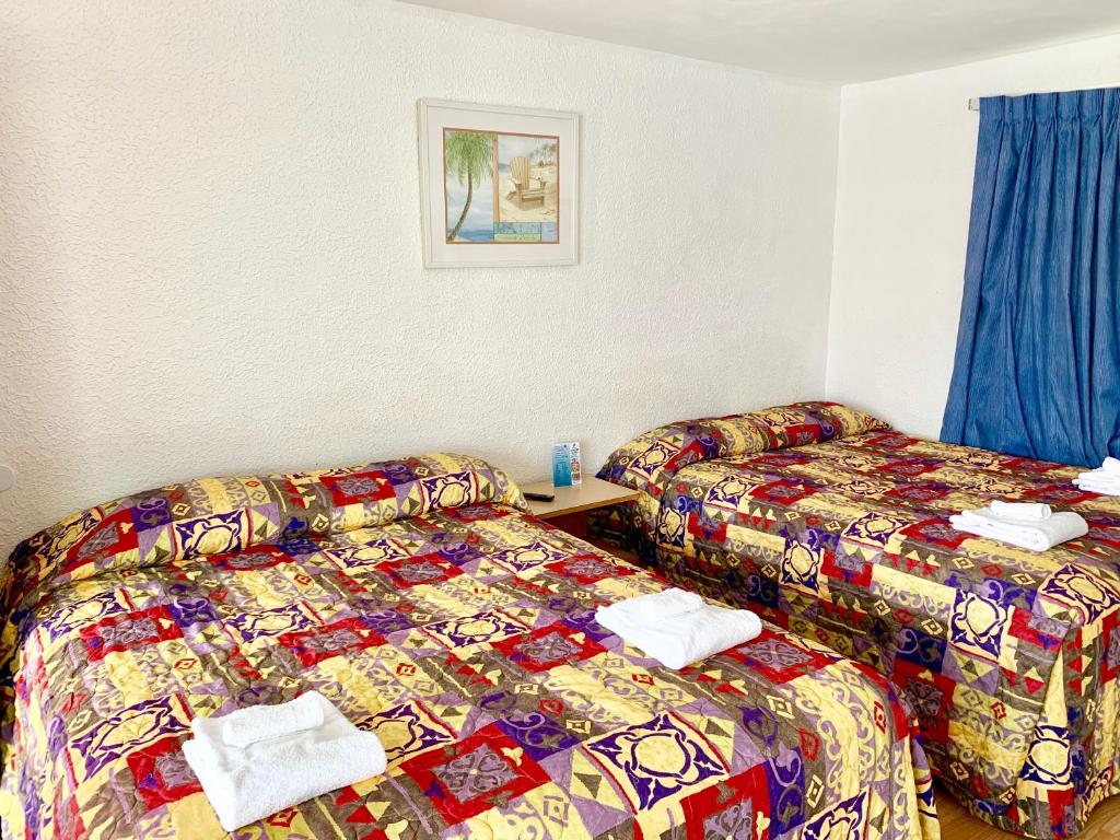 Postel nebo postele na pokoji v ubytování White Caps Motel