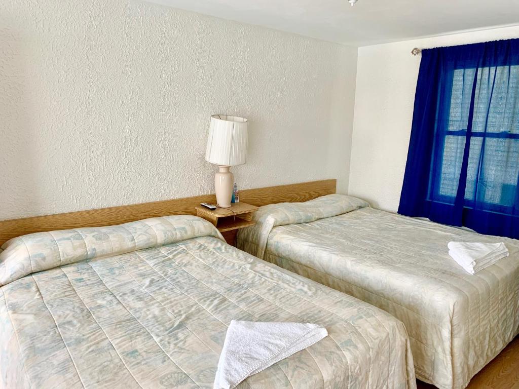 Postel nebo postele na pokoji v ubytování White Caps Motel