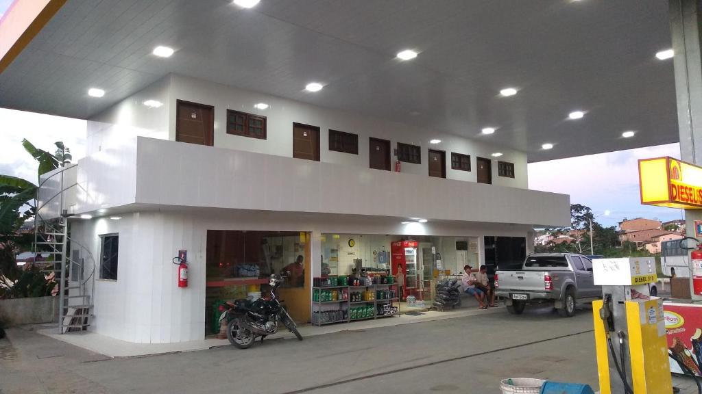 a gas station with a motorcycle parked outside of it at Pousada Bela Vista in Guabiraba