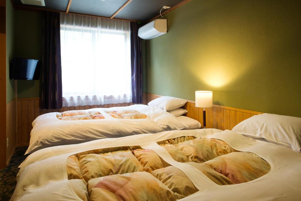 Postel nebo postele na pokoji v ubytování Matsusaki