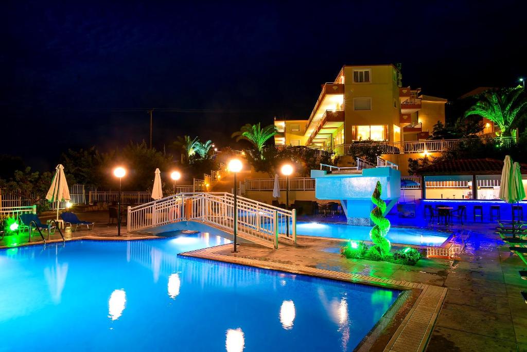duży basen w nocy z oświetleniem w obiekcie Hotel Diamond w Limenárii