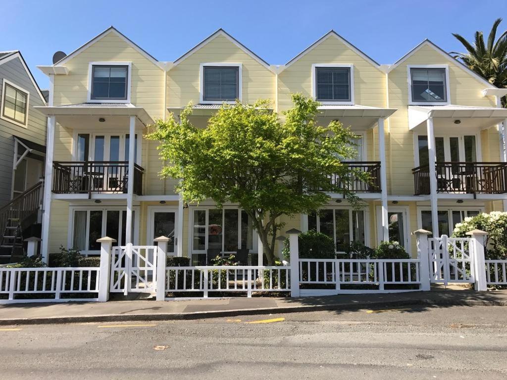 uma cerca branca em frente a uma casa grande em The Bruce Waterfront Apartments by AVI em Akaroa