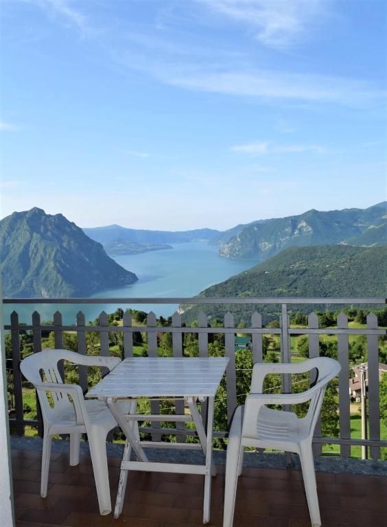 a table and chairs on a balcony overlooking a lake at Panorama Verde Lago - Mountain Lake Iseo Hospitality in Bossico