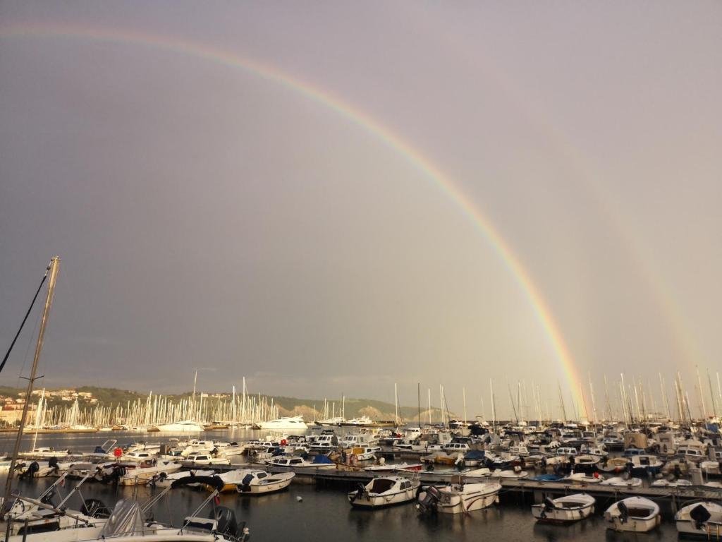 a rainbow over a bunch of boats in a marina at Arcobaleno isolano in Izola