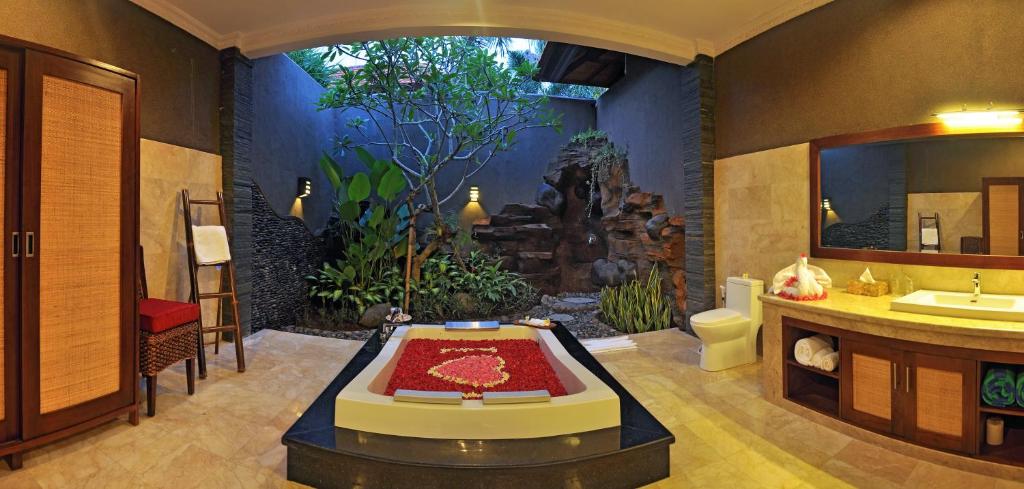 une salle de bain avec une baignoire, un lavabo et des toilettes dans l'établissement Bali Aroma Exclusive Villas, à Seminyak