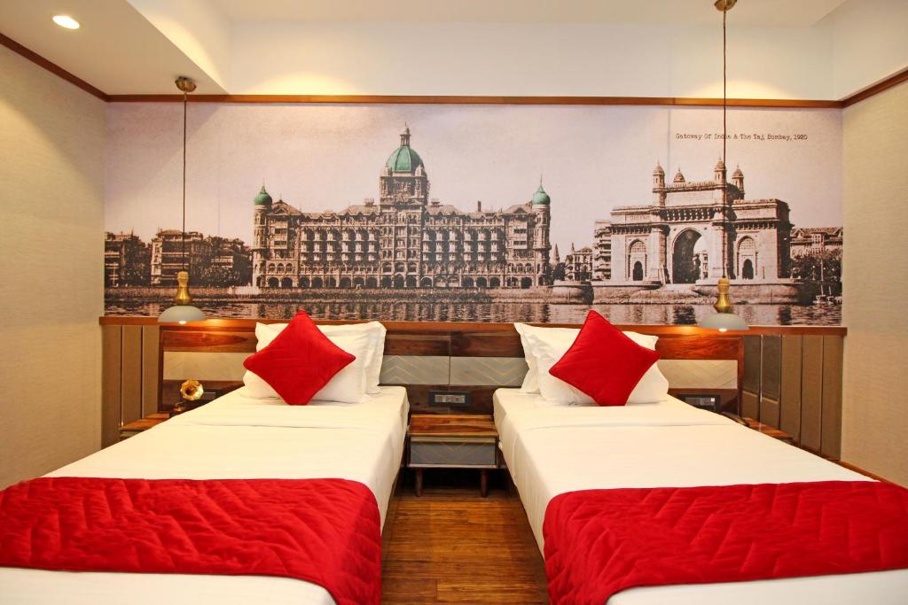 2 Betten in einem Zimmer mit Bild eines Gebäudes in der Unterkunft Theory9 Premium Service Apartments Khar in Mumbai