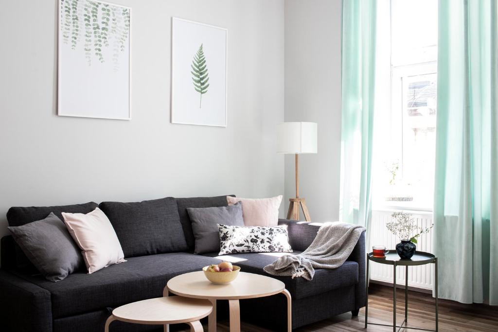 a living room with a black couch and a table at Apartamenty KDN in Bielsko-Biała