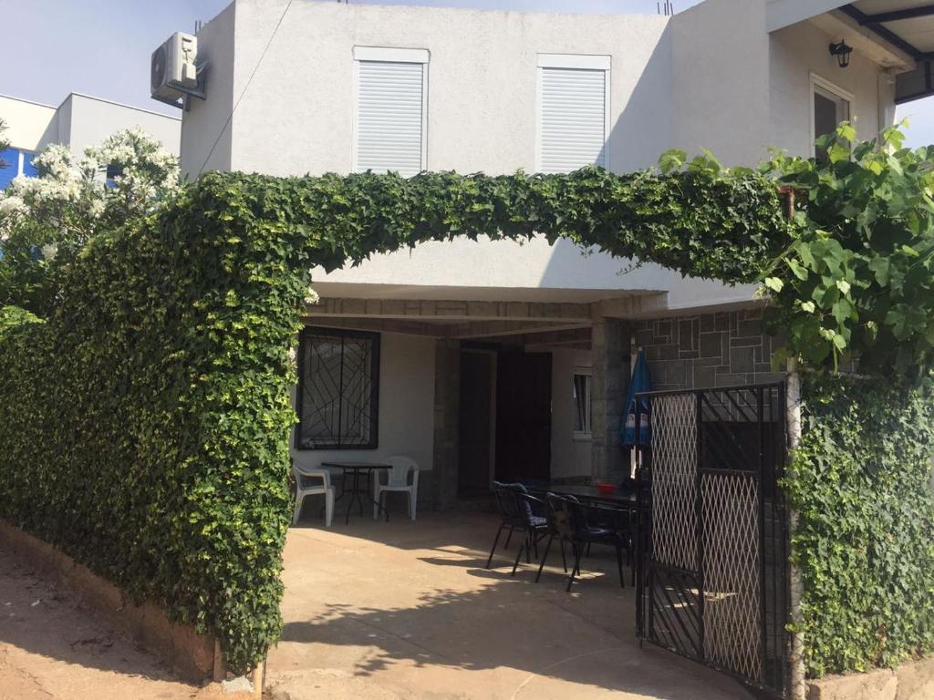 an archway in front of a house with a table and chairs at Apartmani KiKi in Utjeha