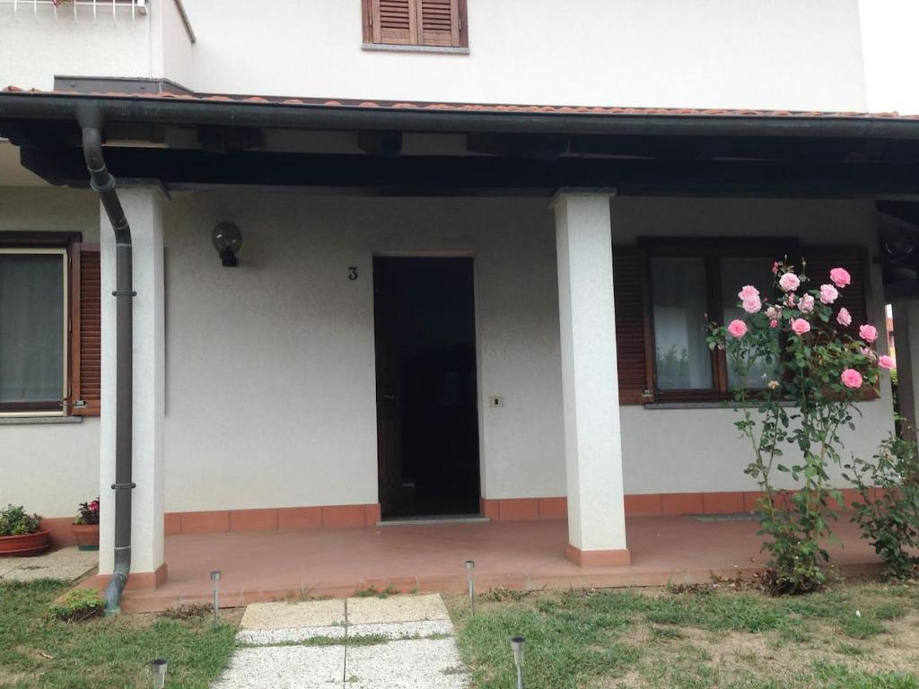 Una casa blanca con una puerta y flores. en A casa di Antonella en Biella