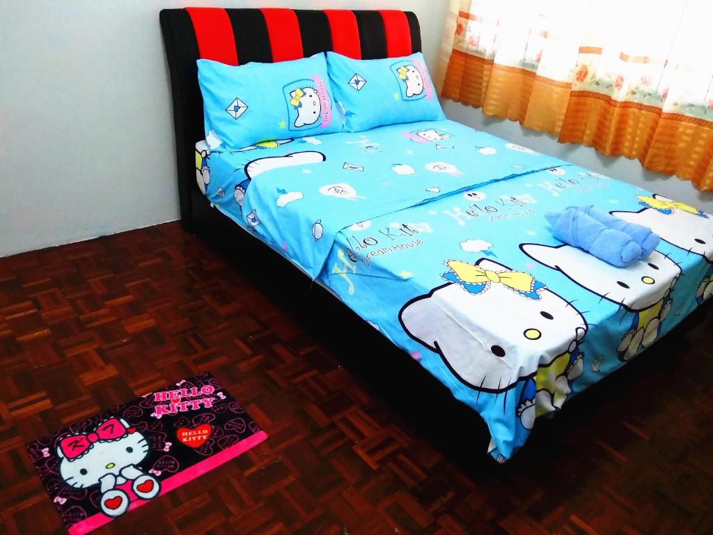een bed met een kattendekbed en kussens bij H Homestay Sibu - 500Mbps Wifi, Full Astro & Private Parking! in Sibu