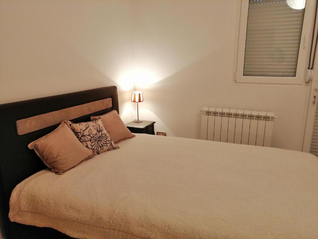 a bedroom with a large bed and a lamp at Studio Apartman Irena1 in Bijela