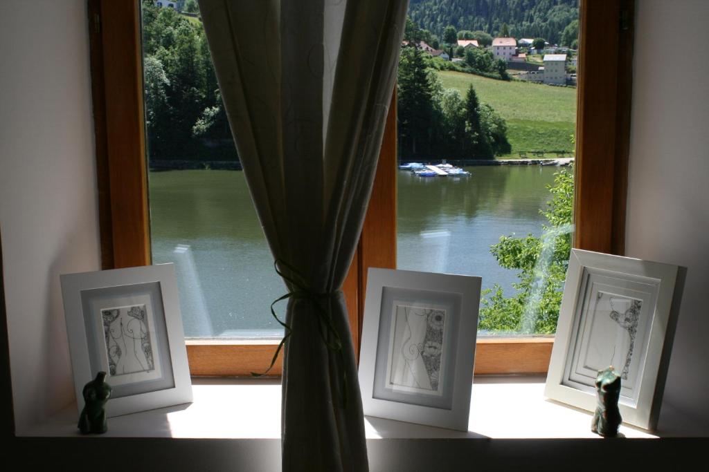 a window with three framed pictures on a window sill at La Combe fleurie in Villers-le-Lac