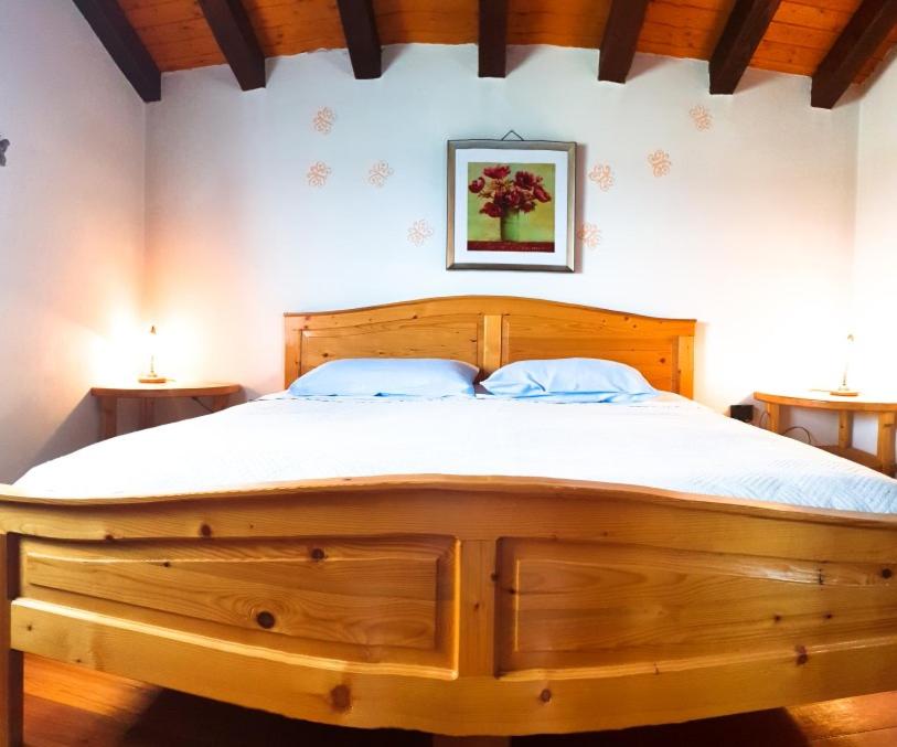a large wooden bed in a bedroom with two tables at Mon Perin Castrum - Apartman Valentina in Bale
