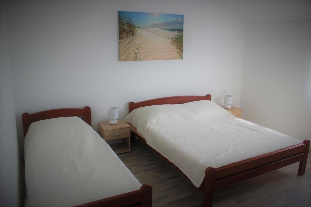2 Letti in una camera con foto di una spiaggia di Apartment Donat a Zara (Zadar)